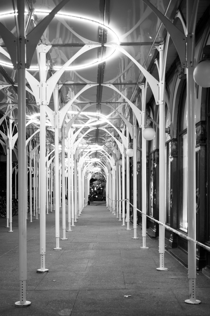 a set of arches and lights at night, in black and white